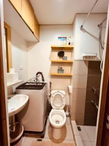 a small bathroom with a toilet and a sink at Condominium at Spring Residences near Airport in Manila