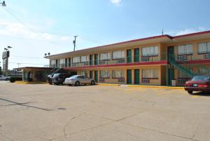 un gran edificio con coches estacionados en un estacionamiento en Travel Inn Motel Michigan City, en Michigan City