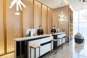 two women standing at a bar in a hotel lobby at Atour Hotel Hefei Changjiang Road in Hefei