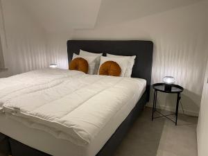 ein Bett mit einer weißen Bettdecke und 2 Kissen in der Unterkunft Le fond d'Or in Borgloon