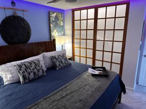 1 dormitorio con 1 cama con sábanas y almohadas azules en This place is different!! No Housekeeping Fees, Award winning! Oceanfront, View View! en Wailuku