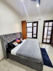 a bedroom with a bed in a room with windows at Luxury Villa with Free Breakfast - RnR Manor in Kālka
