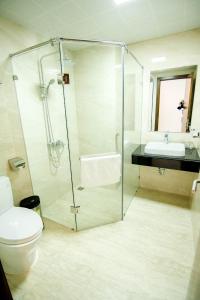 a bathroom with a shower and a toilet and a sink at Hạ Long Land Hotel in Ha Long