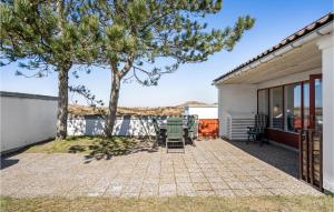 um pátio com cadeiras e uma árvore em frente a uma casa em Beautiful Home In Pandrup With Wifi em Pandrup mais 13 fotografias