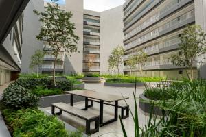 a courtyard in a building with a table and benches at Newlands Peak Aparthotel by Totalstay in Cape Town