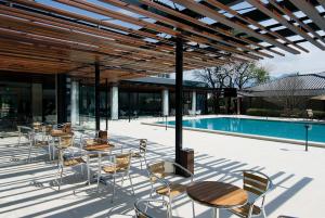 un patio con tavoli e sedie accanto alla piscina di Hotel Fuji a Fuefuki