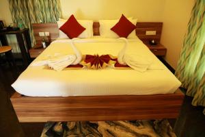 a hotel room with a bed with towels on it at ZIONS HOTEL AND APERTMENT in Devanhalli