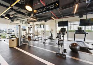 a gym with several treadmills and machines in it at Host and Stay - Collective tower 1, Dubai Hills Estate in Dubai