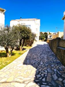 a cobblestone street with trees and a building at Apartment Karlo - city center in Pag