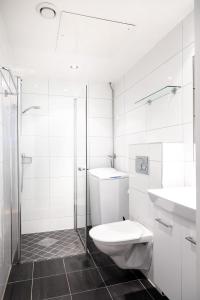 a white bathroom with a toilet and a sink at Frogner House - Bislett in Oslo