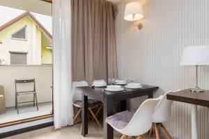 a dining room with a table and white chairs at Seaside Studio with Balcony by Renters in Władysławowo