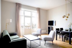een woonkamer met een tafel en stoelen en een piano bij Frogner House - Bislett in Oslo