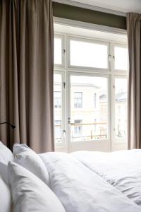 a bedroom with two white beds and a window at Frogner House - Bislett in Oslo