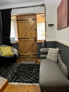a living room with a couch and a wooden door at Woodbriar in Conwy