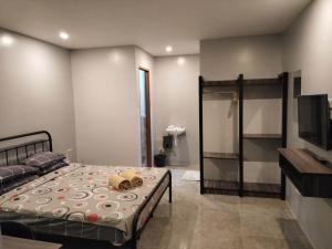 a bedroom with a bed and a tv and a tv at KM Pension in Libug