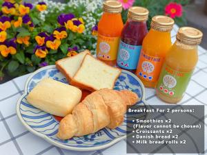 a plate of food with bread and bottles of juice at MEIBI Hakone Yumoto in Hakone