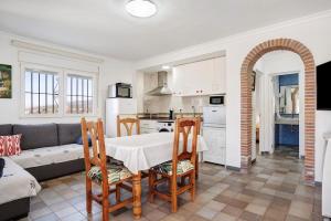 Casa Vistas al Mar Bolonia في تريفة: مطبخ وغرفة معيشة مع طاولة وكراسي