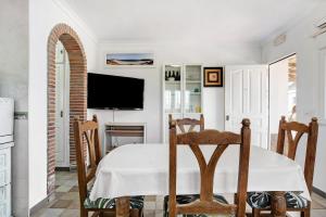 Casa Vistas al Mar Bolonia في تريفة: غرفة طعام مع طاولة وتلفزيون