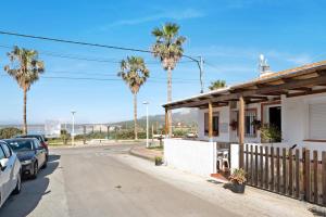 Casa Vistas al Mar Bolonia في تريفة: منزل على جانب شارع فيه نخيل