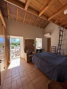 een slaapkamer met een groot bed en een patio bij Villa Horta do Limão 8-10 pessoas a 4 km das praias da Ria Formosa Fuseta in Moncarapacho +39 foto's