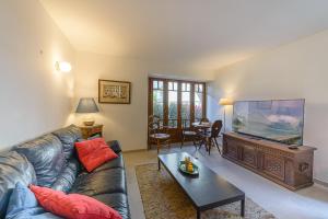 ein Wohnzimmer mit einem Sofa und einem großen Flachbild-TV in der Unterkunft La Grande Mélodie - Maison familiale avec jardin in Saint-Jorioz