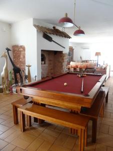 een pooltafel in een woonkamer met een open haard bij Villa Horta do Limão 8-10 pessoas a 4 km das praias da Ria Formosa Fuseta in Moncarapacho