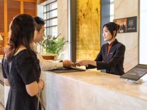 two women standing at a cash register at Dongguan Forum Hotel and Apartment - Former Pullman hotel Dongguan Forum in Dongguan