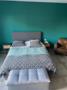 ein Schlafzimmer mit einem Bett und einer blauen Wand in der Unterkunft Villa Lina in Cuers