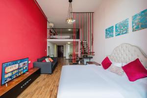 a bedroom with a white bed and a red wall at April Fair Duplex Apartment Guagnzhou South Railway Station Min Jie Branch in Guangzhou