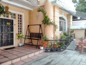 Chelsiefaye Guest House في لواوْغ: شرفة منزل مع مقاعد ونباتات