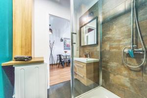 a bathroom with a shower and a sink at Hello Apartments Brzeźno Dworska DARK in Gdańsk