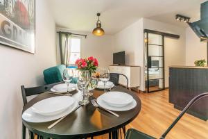 a dining room with a table with wine glasses at Hello Apartments Brzeźno Dworska DARK in Gdańsk