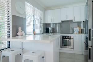 a kitchen with white cabinets and a white counter top at Mindarie Retreat in Mindarie