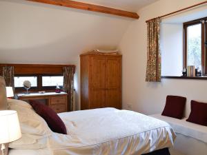 een slaapkamer met een bed, een bureau en een raam bij Chalgrove in Aber-Brân