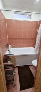een badkamer met een bad, een toilet en een raam bij Ukstiņa Holiday apartment in Liepāja