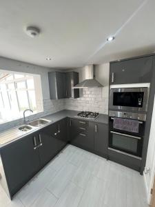 a kitchen with gray cabinets and a stove top oven at 2 bed semi-detached house in Warrington