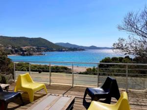 una terrazza con sedie e vista sull'acqua di Villa contemporaine climatisée, vue mer exceptionnelle, à quelques mètres de la plage a Pietrosella