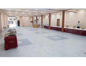 uma grande sala vazia com uma mesa no meio em Hotel Omkar & Restaurant, Uttarkashi em Uttarkāshi