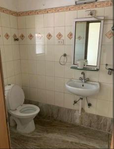 een badkamer met een toilet en een wastafel bij Ballygunge Guest House in Calcutta