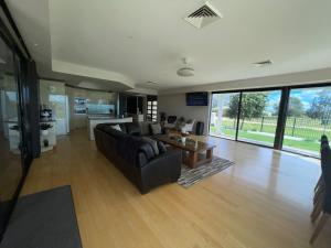 uma sala de estar com um sofá e uma mesa em Luxury at Linthorpe em Yarrawonga