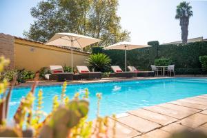 a swimming pool with chairs and umbrellas in a yard at Golden Horse Hotel 