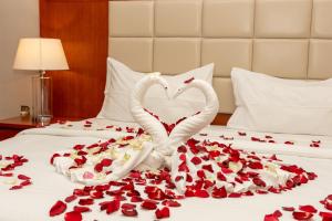 dos cisnes haciendo un corazón en una cama cubierta de rosas en بروج السالمية للشقق المخدومة Brouj Al salmiya apartments Serviced en Dammam