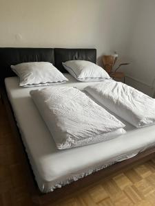 a bed with white sheets and pillows on it at Tor zum Pfälzerwald in Pirmasens
