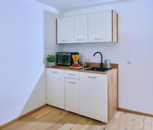 a kitchen with white cabinets and a sink at Ferienwohnung Zimmer Tittmoning Stadtplatz 27 in Tittmoning
