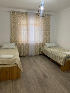 a bedroom with two beds and a window at Бэй Хаус ( The Bay Area) in Cholpon-Ata