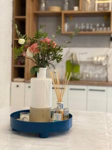 a blue tray with a vase with flowers on a counter at Бэй Хаус ( The Bay Area) in Cholpon-Ata