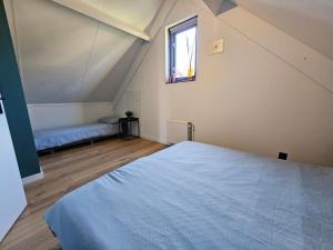 ein Schlafzimmer mit großem Bett und Fenster in der Unterkunft 7 person House with garden, firepit, swimming lake, hammock, child friendly, in- and outside playground, slide, and great coffee in Ewijk