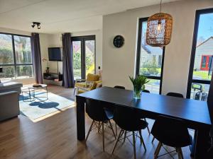 ein Wohnzimmer mit Esstisch und Stühlen in der Unterkunft 7 person House with garden, firepit, swimming lake, hammock, child friendly, in- and outside playground, slide, and great coffee in Ewijk