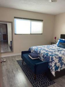 um quarto com uma cama com um edredão azul e uma janela em SUITE Queen Apart South-Bay Beaches em Gardena