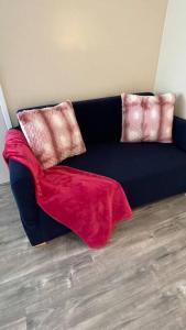 a blue couch with two pink pillows on it at SUITE Queen Apart South-Bay Beaches in Gardena